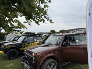 Mehrere Lada Niva nebeneinander unter Bäumen auf dem Treffen-Gelände