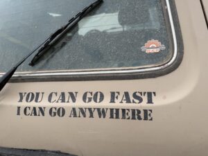 Heckpartie eines beigen Lada Niva mit Offroad-Spruch als Aufkleber