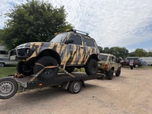 Getarnter Lada Niva Bronto auf einem Anhänger, dahinter ein weiterer Niva in Tarnlackierung