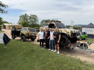 Viktor Derenko mit drei Teilnehmern vor einem Lada Niva Bronto am Stand des Internationalen Lada Niva Treffens 2026