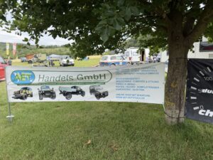 Werbebanner der AET Handels GmbH an einem Baum auf dem Campingplatz beim Internationalen Lada Niva Treffen 2026