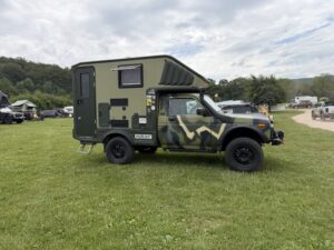 Zum Wohnmobil umgebauter Lada Niva mit Tarnlackierung und Aufstelldach