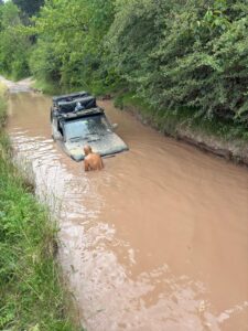 Fahrer birgt einen in einem Wasserloch stecken gebliebenen Lada Niva